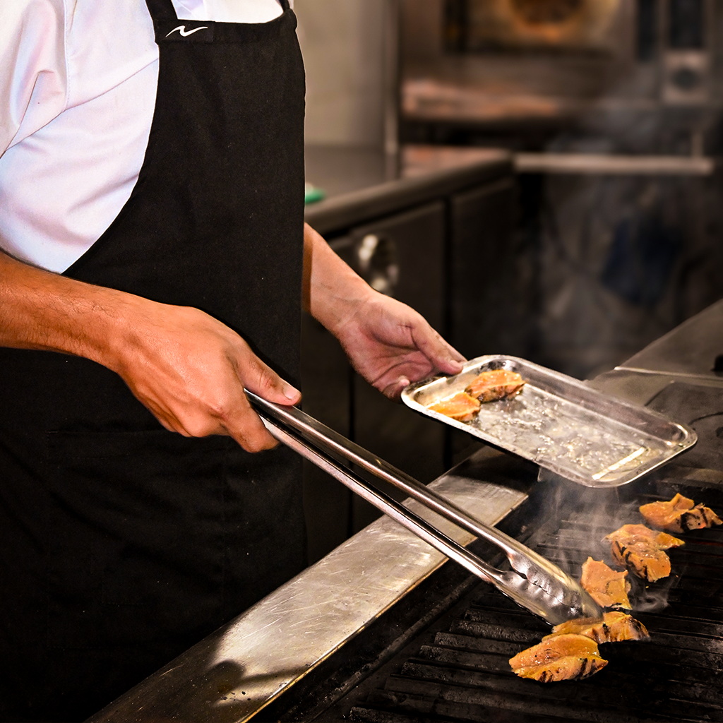 Chef de Morada Ancestral cocinando sobre las brasas del fogón de leña